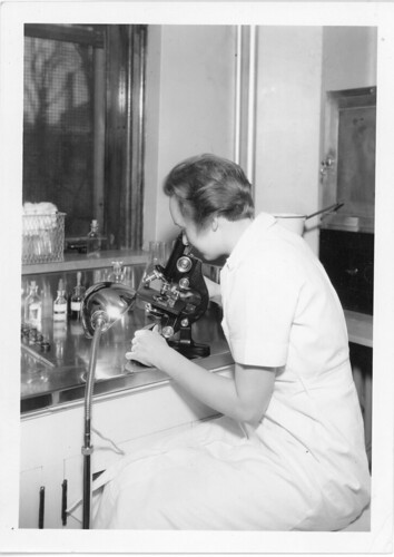 Laboratory Employee Views Samples Through a Microscope | by MPLSArchives